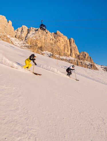 Skifahrer Abfahrt König Laurin Piste - Rosengarten im Abendrot | © Carezza Dolomites/Harald Wisthaler