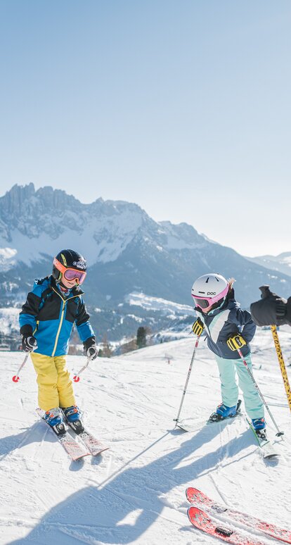 Sciare in famiglia con vista sul Latemar innevato | © Carezza Dolomites/Harald Wisthaler