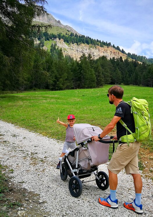 Padre con bambino e passeggino sotto il Catinaccio | © Clicktext