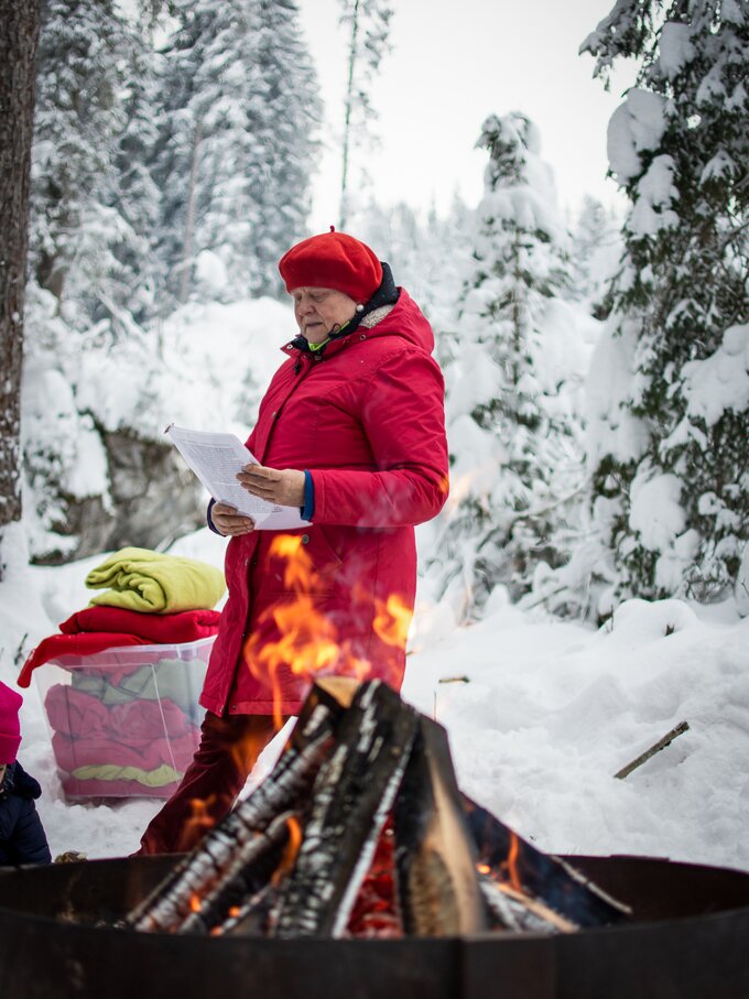 Lesende Frau beim Lagerfeuer | © Alexandra Näckler