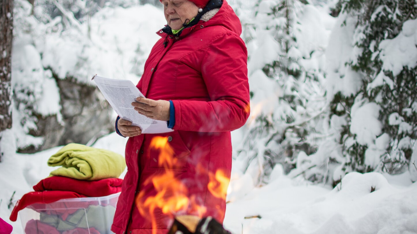 Lesende Frau beim Lagerfeuer | © Alexandra Näckler