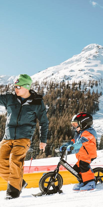Father and son ski bike winter Latemar | © StorytellerLabs