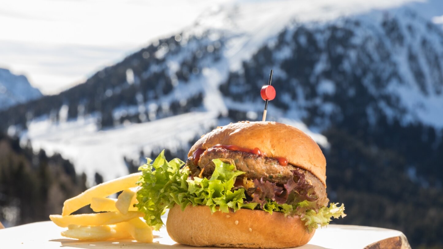 Burger mit Blick auf Skipisten in Obereggen | © Günther Pichler