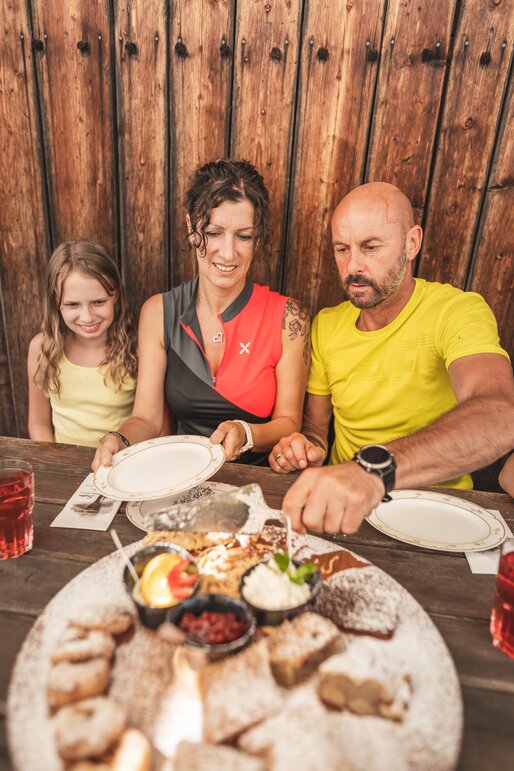 Familie, Dessertplatte, traditionelle Alm | © Eggental Tourismus/Thomas Monsorno