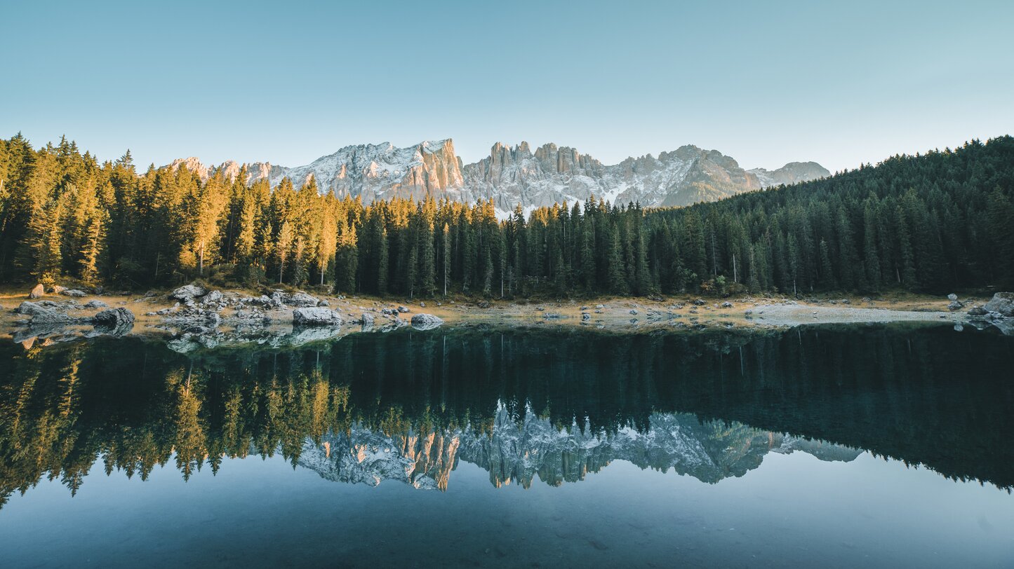 Lago di Carezza acqua colorata - prima neve sul Latemar | © Carezza Dolomites/StorytellerLabs