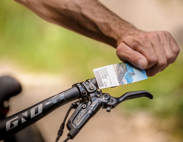 Biker with lift ticket in hand | © Eggental Tourismus/Jens Staudt