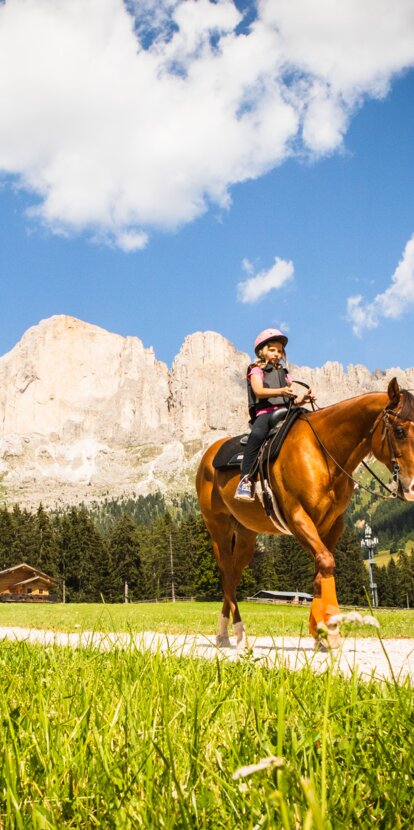 Child riding, brown horse, view Rosengarten | © Eggental Tourismus/StorytellerLabs