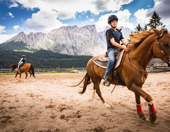 Riding arena with view of Latemar | © Eggental Tourismus/StorytellerLabs