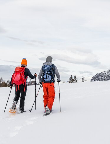Snowshoe hikers in fresh snow with a view of Schlern | © Eggental Tourismus/Clicktext
