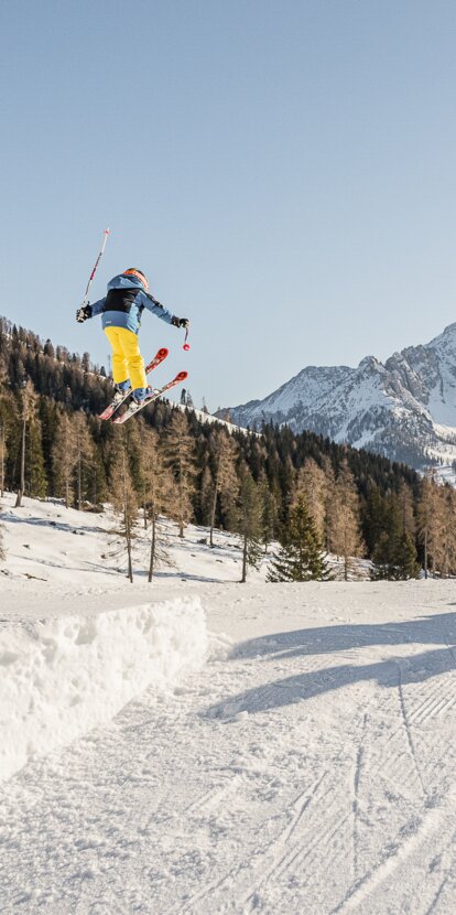 Jump child over kicker View Latemar | © Carezza Dolomites/Harald Wisthaler