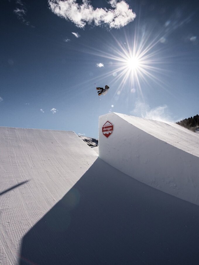 Sprung über Hügel Snowboarder Sonnenstrahlen | © Obereggen Latemar AG/F-Tech