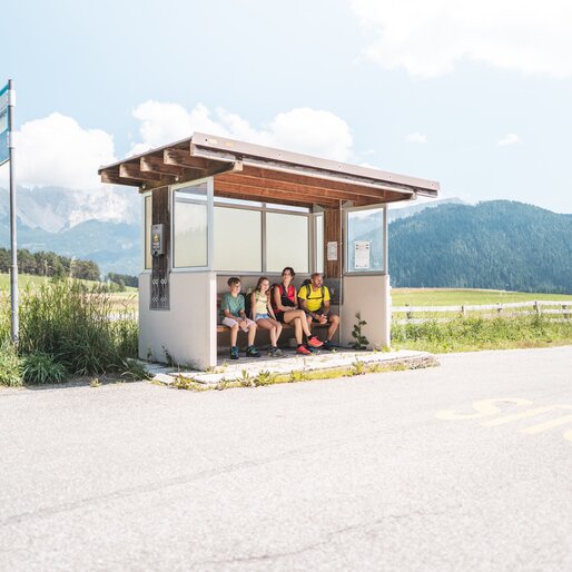 Famiglia che aspetta l'autobus alla fermata | © Thomas Monsorno