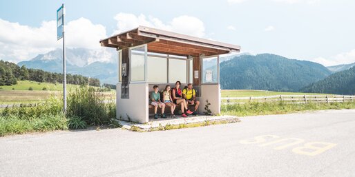 Familie wartet auf dem Bus an der Bushaltestelle | © Thomas Monsorno
