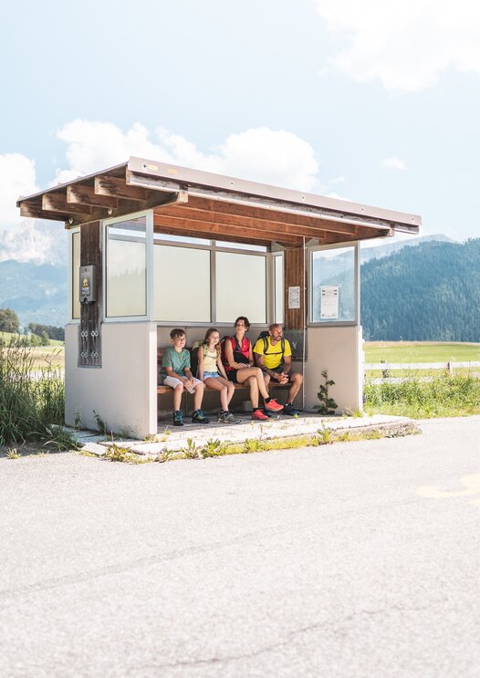 Familie wartet auf dem Bus an der Bushaltestelle | © Thomas Monsorno