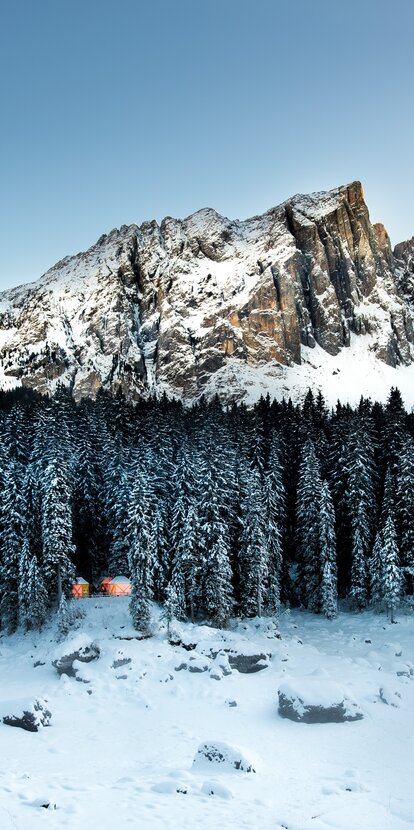 Latemar Lake Carezza winter landscape illuminated wooden huts | © Armin Mair (Indio)