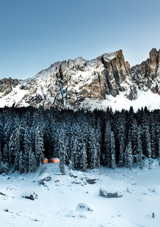 Latemar Karer See Winterlandschaft leuchtende Holzhütten | © Armin Mair (Indio)