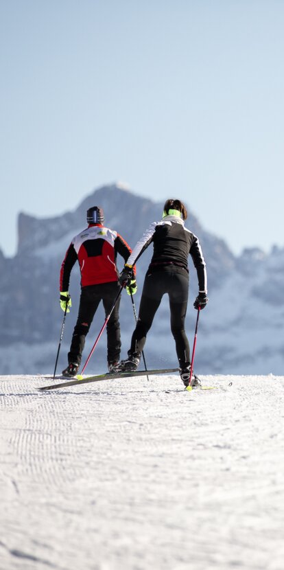 Due sciatori di fondo su una pista perfettamente preparata di Nova Ponente con vista sul Catinaccio | © Eggental Tourismus/Günther Pichler