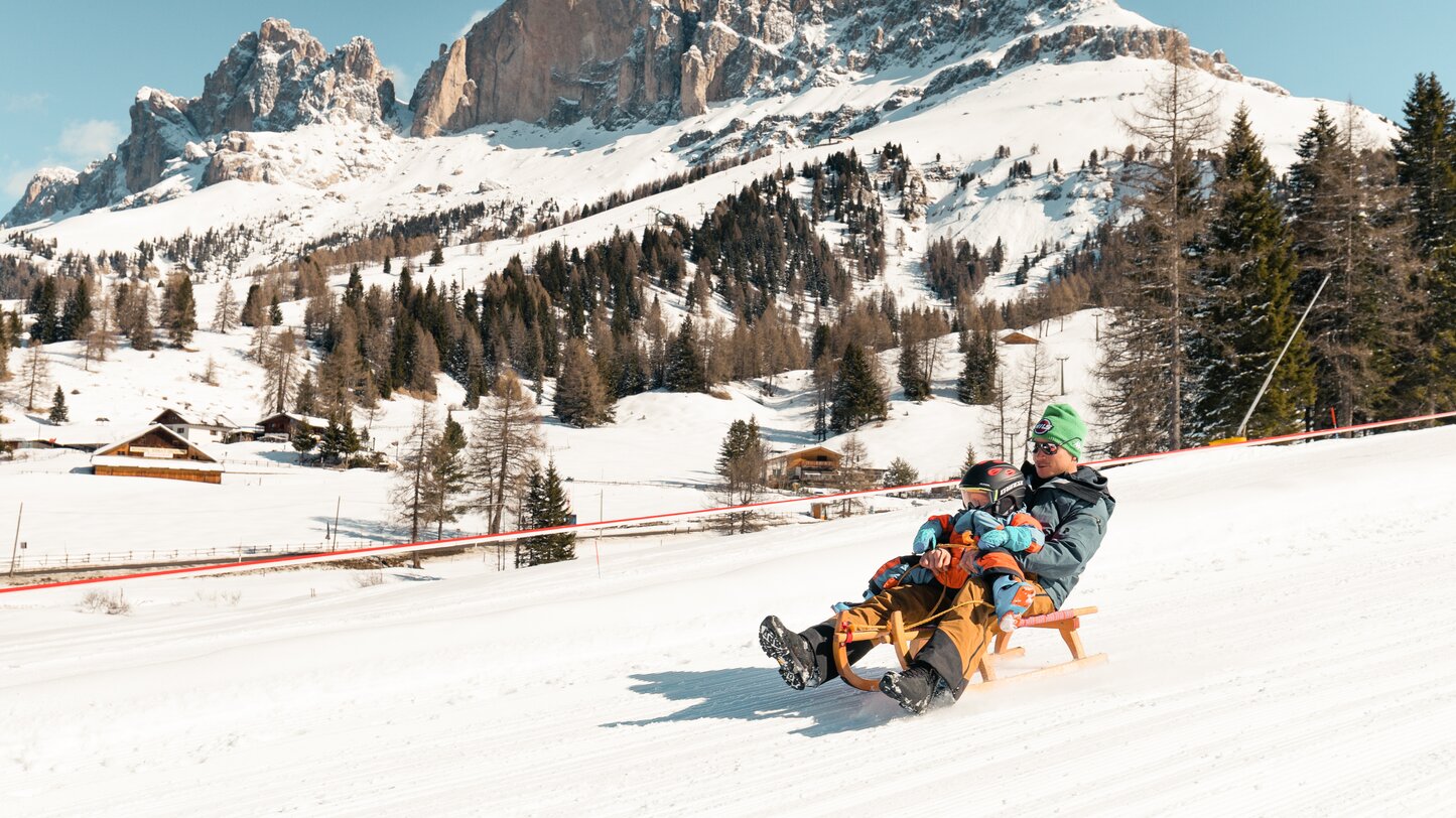 Father and son tobogganing Rosengarten winter | © StorytellerLabs