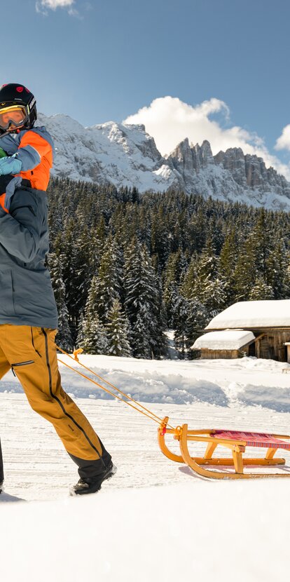 Vater und Sohn Schlittenfahren Aussicht Latemar | © Carezza Dolomites/StorytellerLabs